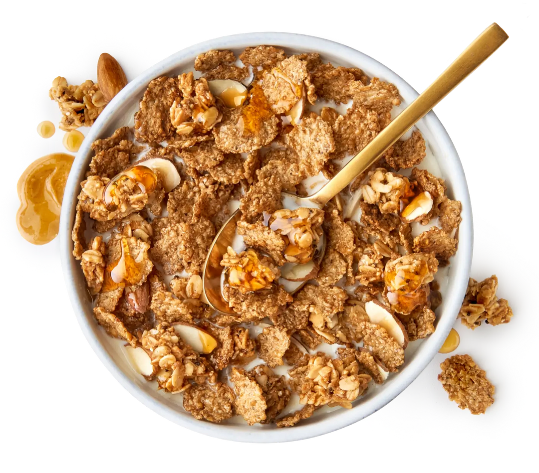 A bowl of cereal with granola, almonds, walnuts and a gold spoon